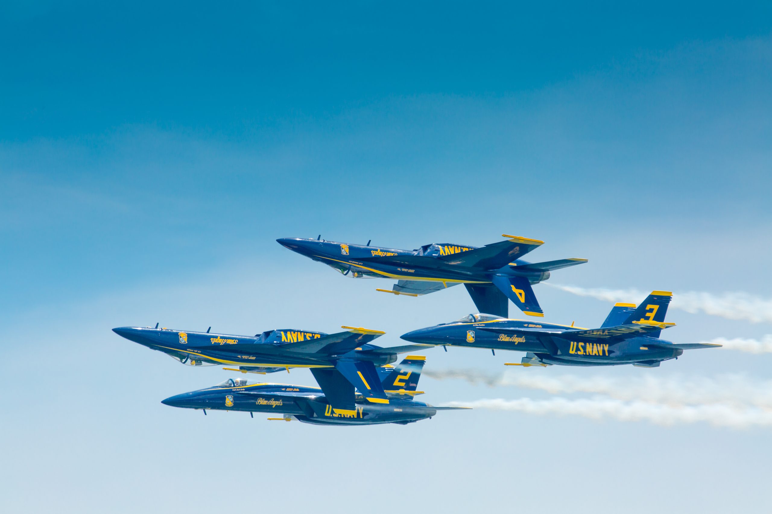 Four blue fighter jets in formation